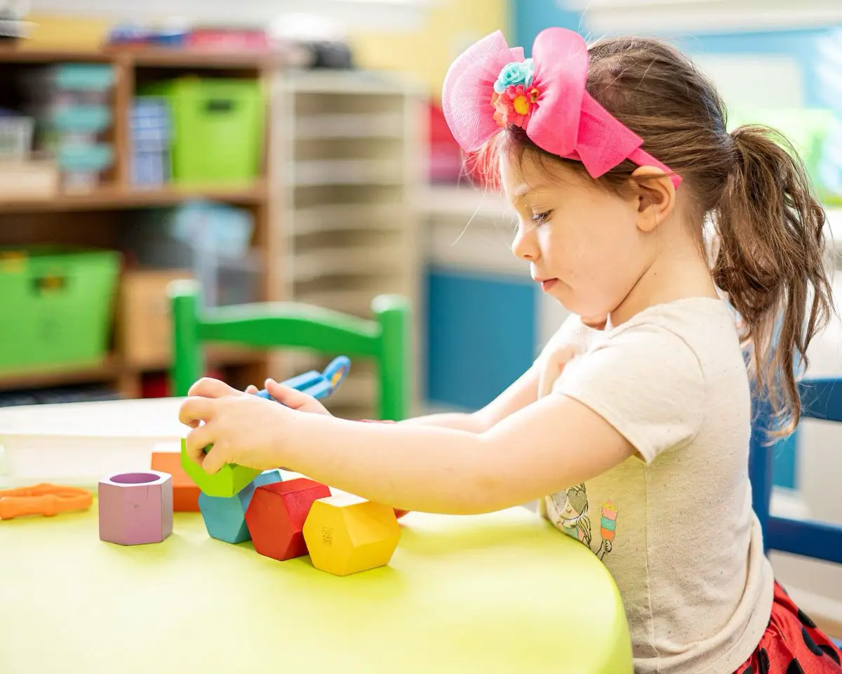 Little School girl playing with blocks