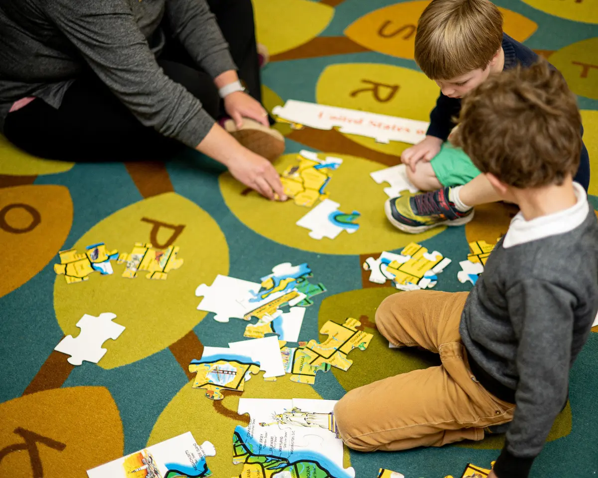 Little School Students putting together a puzzle on the rug